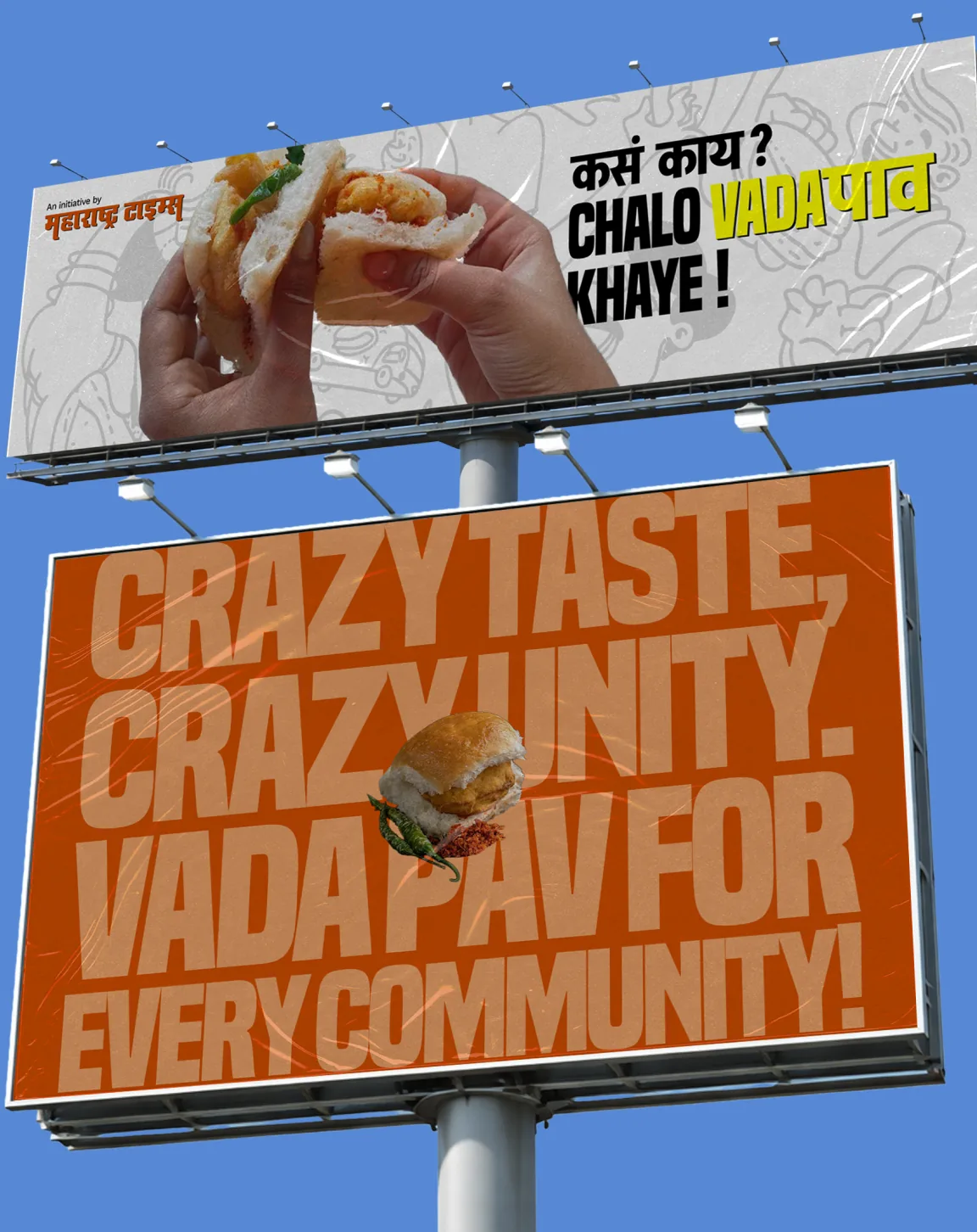 Two billboards against a blue sky: a hand holding a vada pav, and “Crazy taste, crazy unity. Vada pav for every community!”