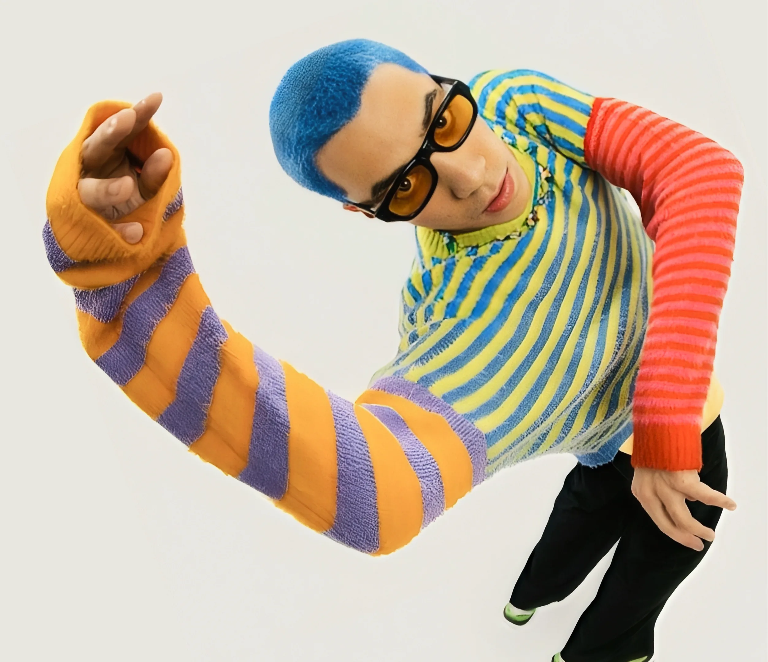 A model in a striped orange and purple sleeve, pointing at the camera.